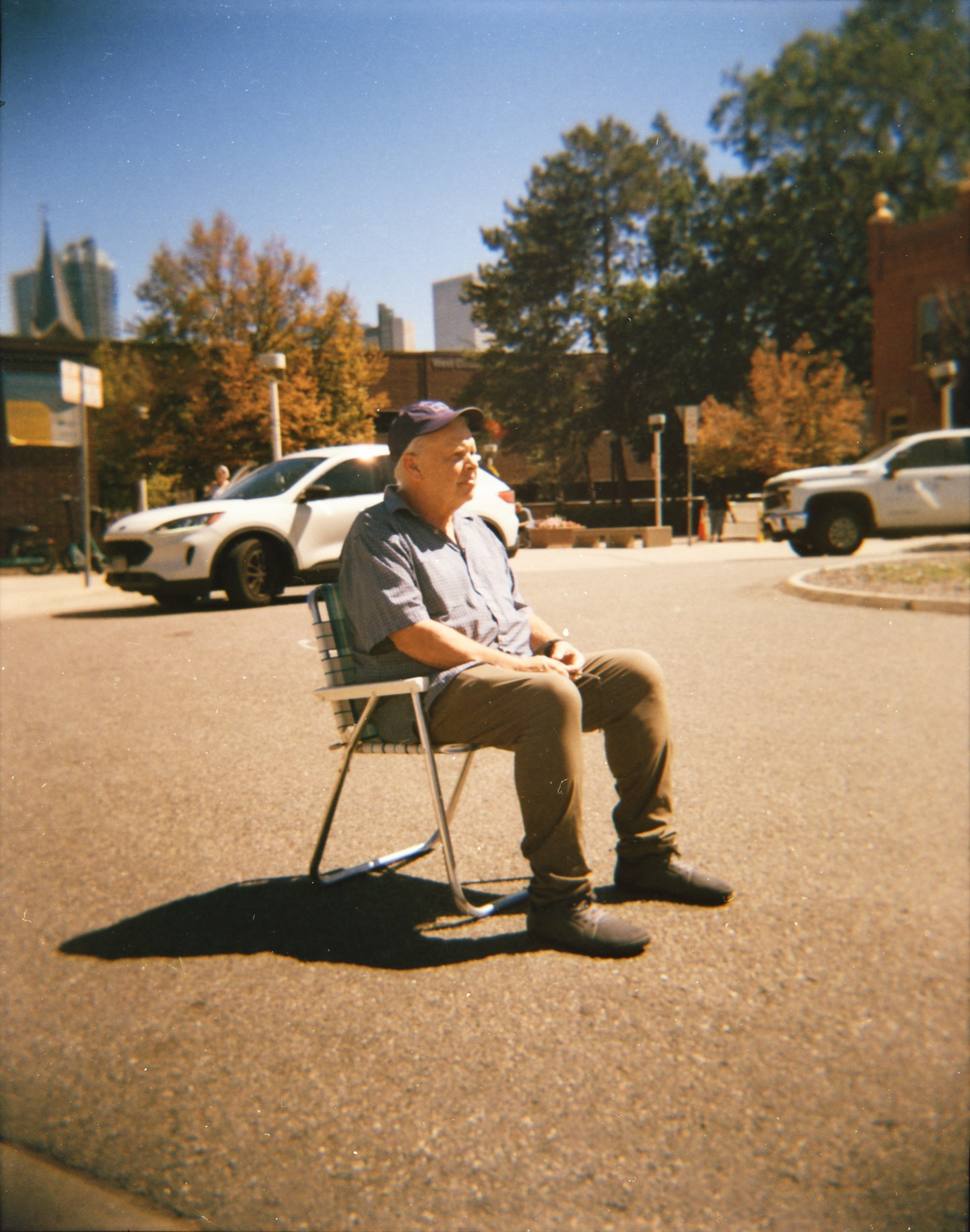 Performance photograph of a seated figure in an open parking area