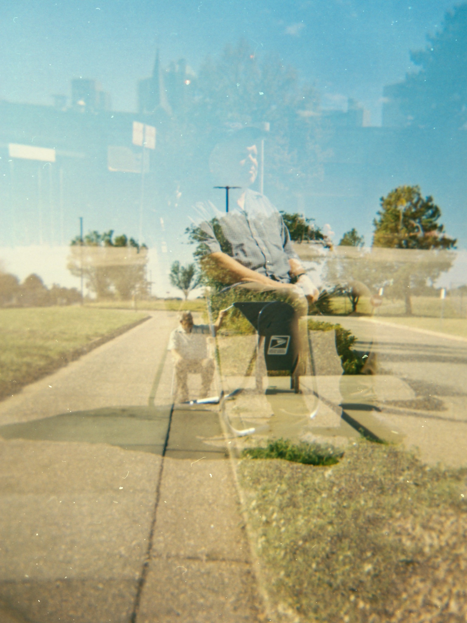 Double-exposure style performance photograph near a roadside mailbox